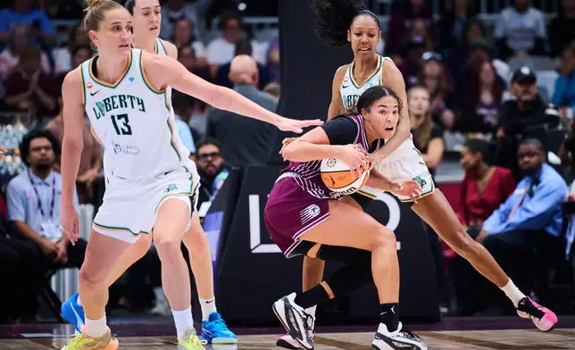 Toronto Tempo's Kiki Rice, front right, looks to pass the ball as New York Liberty's Rebekah Gardner, back right, defends during the first half of a WNBA basketball game in Toronto, Sunday, Sept. 20, 2026. (Sammy Kogan/The Canadian Press via AP)