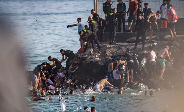 FILE - Migrants try to cross from Morocco into the Spanish enclave of Ceuta, July 30, 2026. (AP Photo/Antonio Sempere, File)