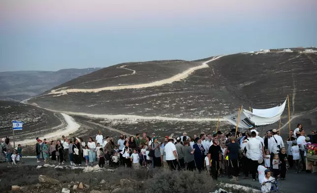 Israeli settlers celebrate the inauguration of a newly built synagogue at the occupied West Bank outpost of Homesh, Wednesday, Sept. 16, 2026. (AP Photo/Ohad Zwigenberg)