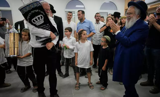 Israeli settlers celebrate the inauguration of a newly built synagogue at the occupied West Bank outpost of Homesh, Wednesday, Sept. 16, 2026. (AP Photo/Ohad Zwigenberg)