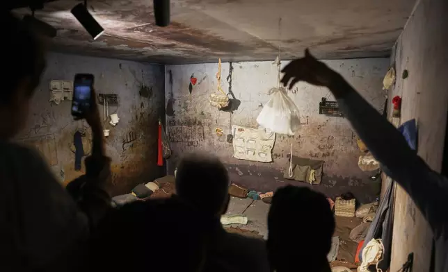 Visitors view a recreation of a cell at Military Security Branch 248 containing original items from the facility, at "When the Walls Speak," an exhibit at the Damascus International Fair about prisons during the rule of former President Bashar Assad, in Damascus, Syria, Monday, Aug. 31, 2026.(AP Photo/Ghaith Alsayed)
