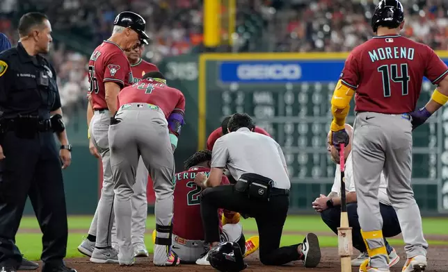 Arizona Diamondbacks' Geraldo Perdomo (2) is helped after being hit by a line drive by Ketel Marte during the third inning of a baseball game against the Houston Astros Sunday, Sept. 6, 2026, in Houston. (AP Photo/David J. Phillip)