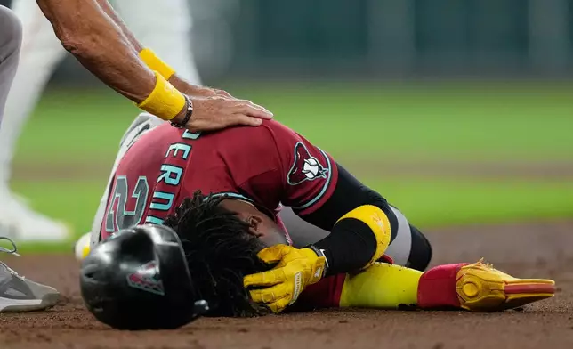 Arizona Diamondbacks' Geraldo Perdomo (2) holds his head after being hit by a line drive by Ketel Marte during the third inning of a baseball game against the Houston Astros Sunday, Sept. 6, 2026, in Houston. (AP Photo/David J. Phillip)