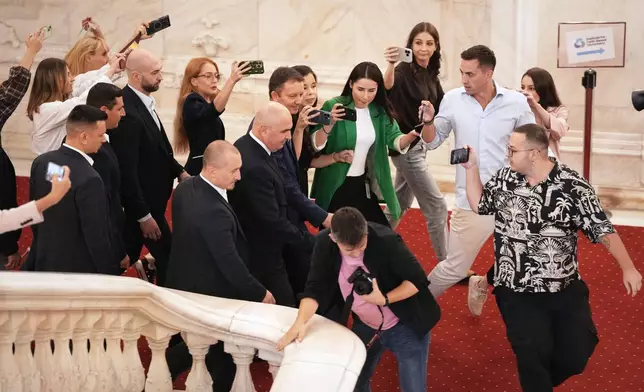 Romanian Prime Minister designate and European Parliament member Siegfried Muresan leaves surrounded by media after a press conference along with outgoing Prime Minister Ilie Bolojan in Bucharest, Romania, Friday, Sept. 18, 2026. (AP Photo/Andreea Alexandru)