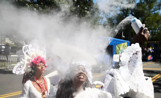 Members of the Belmont Baby Dolls throw baby powder as they wait for the start of the West Indian Day Parade on Monday, Sept. 7, 2026, in the Brooklyn borough of New York. (AP Photo/Heather Khalifa)