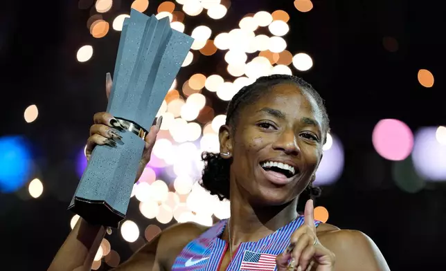 Melissa Jefferson-Wooden, of the United States, poses with her trophy after winning the women's 200 meters final at the World Athletics Ultimate Championship in Budapest, Hungary, Sunday, Sept. 13, 2026. (AP Photo/Matthias Schrader)