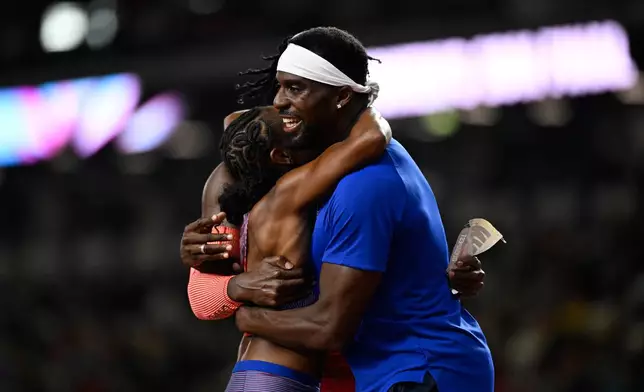 Melissa Jefferson-Wooden, of the United States, and Kenneth Bednarek, of the United States, right, hug each other after winning the women's 200 meters final and the men's 200 meters final, respectively, during the World Athletics Ultimate Championship in Budapest, Hungary, Sunday, Sept. 13, 2026. (AP Photo/Denes Erdos)