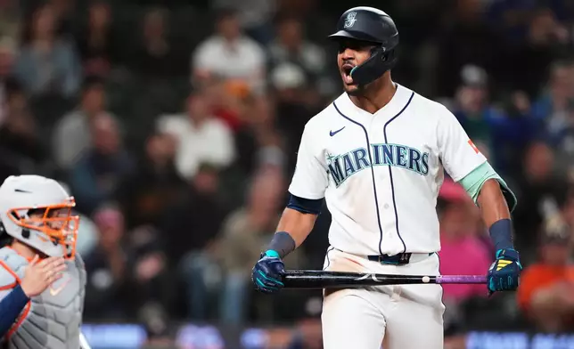 Seattle Mariners' Julio Rodríguez reacts to drawing a bases-loaded walk to drive in a run and tie the game against the Houston Astros during the 10th inning of a baseball game, Wednesday, Sept. 23, 2026, in Seattle. (AP Photo/Lindsey Wasson)