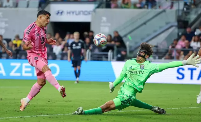 Inter Miami forward Luis Suárez, left, shoots as San Diego FC goalkeeper CJ Dos Santos, right, defends during the first half of an MLS soccer game, Sunday, Sept. 20, 2026, in Miami. (AP Photo/David Santiago)