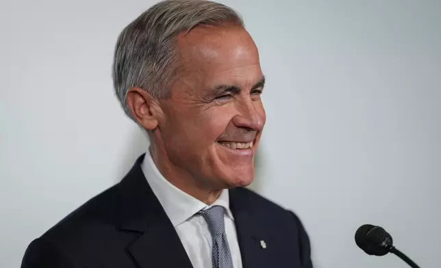 Canada Prime Minister Mark Carney laughs when asked if Canada will apologize to the U.S. for the sake of a trade deal, during an announcement about funding for oceans protection, in North Vancouver, British Columbia, Canada, Tuesday, Sept. 29, 2026. (Darryl Dyck/The Canadian Press via AP)