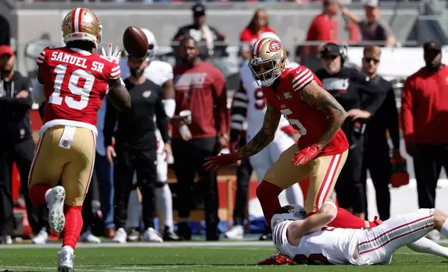 San Francisco 49ers wide receiver Deebo Samuel Sr. (19) catches a lateral from wide receiver Mike Evans (5) before running for a touchdown on the play during the first half of an NFL football game against the Arizona Cardinals in Santa Clara, Calif., Sunday, Sept. 27, 2026. (AP Photo/Kelley L. Cox)