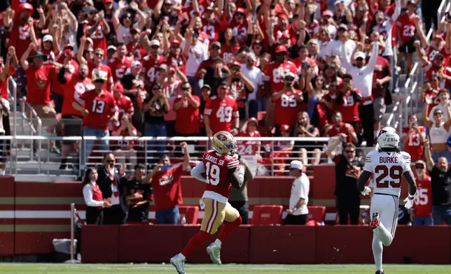 San Francisco 49ers wide receiver Deebo Samuel Sr. (19) runs toward the end zone past Arizona Cardinals cornerback Denzel Burke (29) to score during the first half of an NFL football game in Santa Clara, Calif., Sunday, Sept. 27, 2026. (AP Photo/Kelley L. Cox)