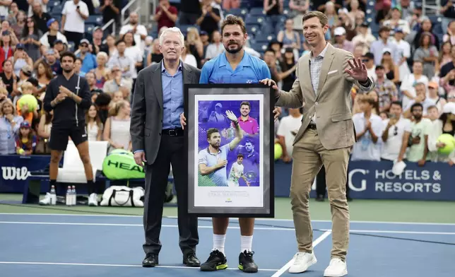 Stan Wawrinka, of Switzerland, center, poses after he lost his match to Matteo Berrettini, of Italy, during the first round of the U.S. Open tennis championships Monday, Aug. 31, 2026, in New York. (AP Photo/Adam Hunger)