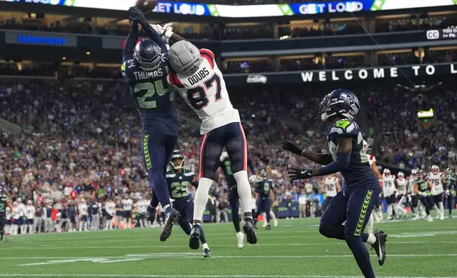 Seattle Seahawks safety Rodney Thomas II (24) goes up for a pass intended for New England Patriots wide receiver Romeo Doubs (87) as Seattle Seahawks cornerback Nehemiah Pritchett (28), right, looks for and will intercept the ball during the second half of an NFL football game, Wednesday, Sept. 9, 2026, in Seattle. (AP Photo/Lindsey Wasson)