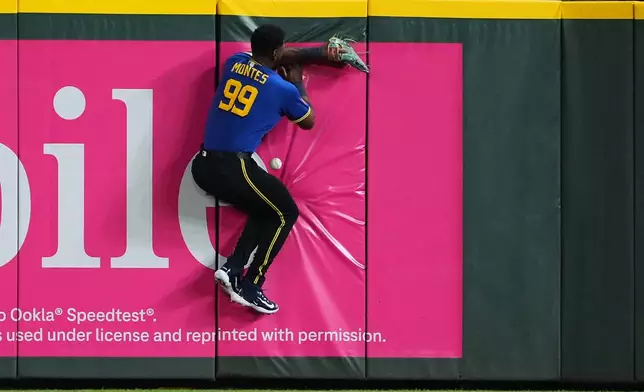 Seattle Mariners right fielder Lazaro Montes crashes into the outfield wall while trying to catch the RBI triple from Athletics' Zack Gelof during the fifth inning of a baseball game, Friday, Sept. 4, 2026, in Seattle. (AP Photo/Lindsey Wasson)