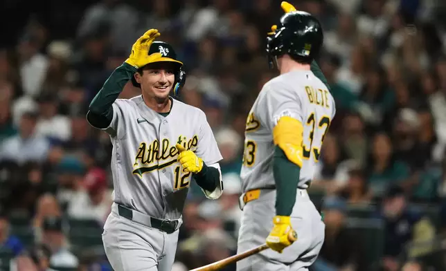 Athletics' Alika Williams (12) greets teammate Henry Bolte (33) after hitting a solo home run against the Seattle Mariners during the third inning of a baseball game, Friday, Sept. 4, 2026, in Seattle. (AP Photo/Lindsey Wasson)