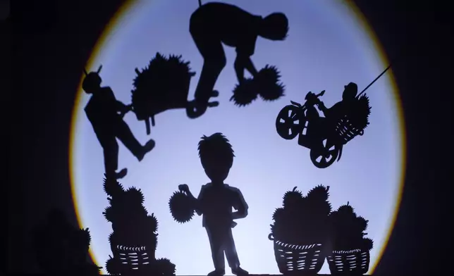 A shadow performance depicting the harvesting and transportation of durians is presented at KLDEX (Kuala Lumpur Durian Experience Centre) in Kuala Lumpur, Malaysia, Friday, June 26, 2026. (AP Photo/Vincent Thian)