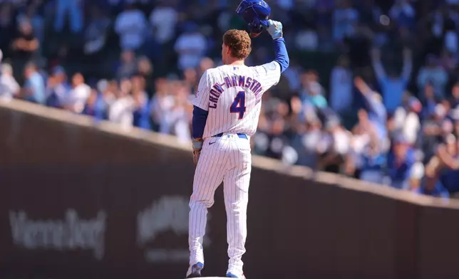 Chicago Cubs' Pete Crow-Armstrong raises his helmet to the crowd after stealing second base for his 40th steal of the season during the first inning of a baseball game against the Miami Marlins, Thursday , Sept. 24, 2026, in Chicago. (AP Photo/Melissa Tamez)