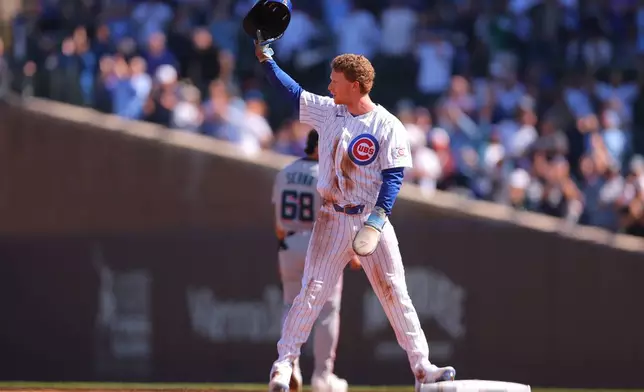 Chicago Cubs' Pete Crow-Armstrong raises his helmet to the crowd after stealing second base for his 40th steal of the season during the first inning of a baseball game against the Miami Marlins, Thursday , Sept. 24, 2026, in Chicago. (AP Photo/Melissa Tamez)