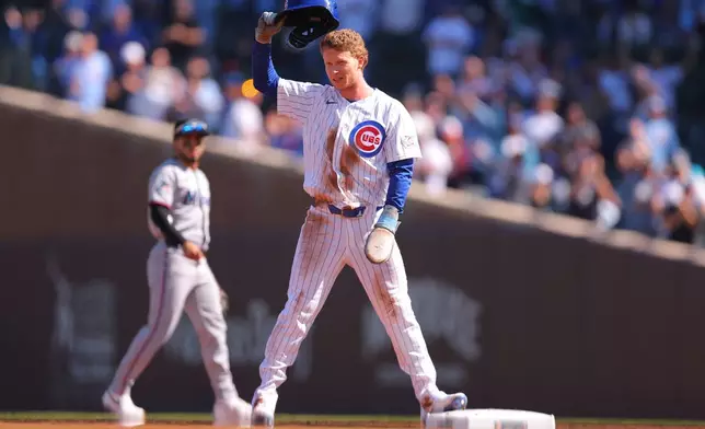 Chicago Cubs' Pete Crow-Armstrong raises his helmet to the crowd after stealing second base for his 40th steal of the season during the first inning of a baseball game against the Miami Marlins, Thursday , Sept. 24, 2026, in Chicago. (AP Photo/Melissa Tamez)