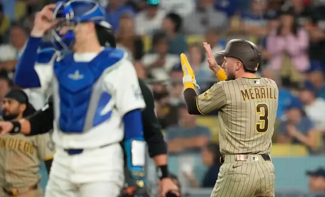 San Diego Padres' Jackson Merrill, right, claps after scoring on a single by Austin Hays as Los Angeles Dodgers catcher Hunter Feduccia stands by during the seventh inning of a baseball game Thursday, Sept. 24, 2026, in Los Angeles. (AP Photo/Mark J. Terrill)