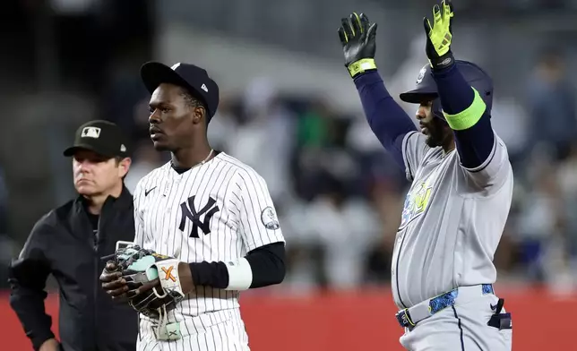 Tampa Bay Rays designated hitter Yandy Díaz reacts next to New York Yankees second baseman Jazz Chisholm Jr. after hitting a two-run scoring single in the ninth inning during the second baseball game of a doubleheader against the New York Yankees, Tuesday, Sept. 22, 2026, in New York. (AP Photo/Adam Hunger)
