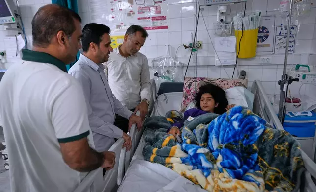 Relatives visit Kiana Karimi, 14, who was wounded during a strike what Iranian media said was a U.S. strike late Tuesday, in Kuhestak, as she lies on the bed in a hospital in town of Minab in southern Iran, Saturday, Sept. 5, 2026. (AP Photo/Vahid Salemi)