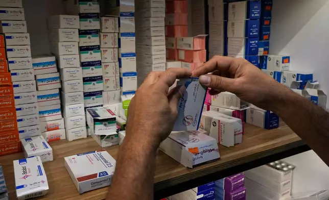A pharmacy worker arranges boxes of medicine on shelves at a pharmacy in Tehran, Iran, Monday, Sept. 21, 2026. (AP Photo/Vahid Salemi)