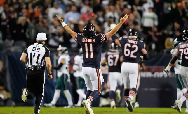 Chicago Bears quarterback Case Keenum (11) celebrates after throwing a touchdown pass to wide receiver Kalif Raymond as referee Shawn Hochuli (83) runs past during the second half of an NFL football game against the Philadelphia Eagles in Chicago, Monday, Sept. 28, 2026. (AP Photo/Nam Y. Huh)