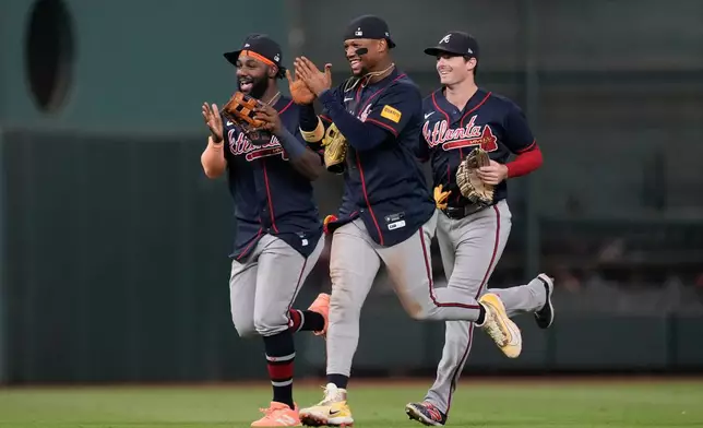 Atlanta Braves center fielder Michael Harris II, left, right fielder Ronald Acuña Jr., center, and left fielder Mike Yastrzemski celebrate after winning a baseball game against the Houston Astros in Houston, Saturday, Sept. 19, 2026. (AP Photo/Ashley Landis)