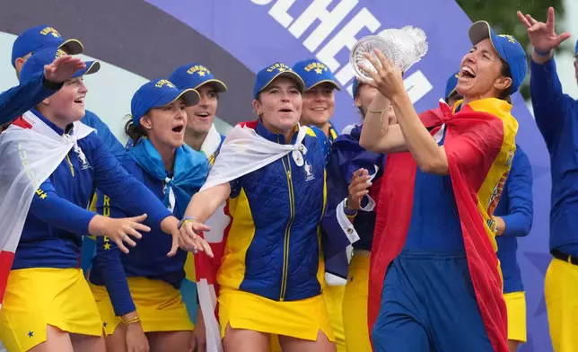 Carlota Ciganda of Europe holds the trophy as she celebrates with teammates after they won the Solheim Cup in Den Bosch, Netherlands, Sunday, Sept. 13, 2026. (AP Photo/Alastair Grant)