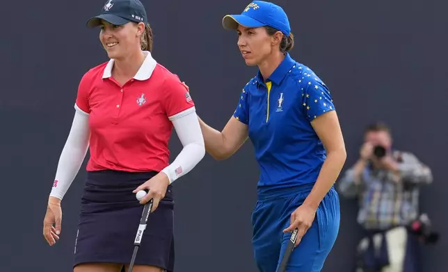 Carlota Ciganda of Europe, right, greets Jennifer Kupcho of the United States on the 16th green after winning their singles match during the final day of the Solheim Cup in Den Bosch, Netherlands, Sunday, Sept. 13, 2026. (AP Photo/Alastair Grant)