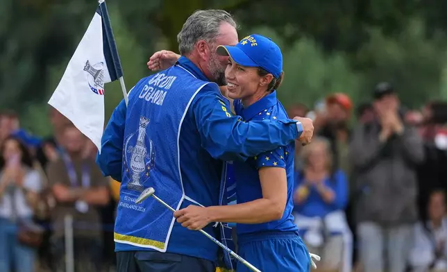 Carlota Ciganda of Europe embraces her caddie on the 16th green after beating Jennifer Kupcho of the United States in a singles match during the final day of the Solheim Cup in Den Bosch, Netherlands, Sunday, Sept. 13, 2026. (AP Photo/Alastair Grant)