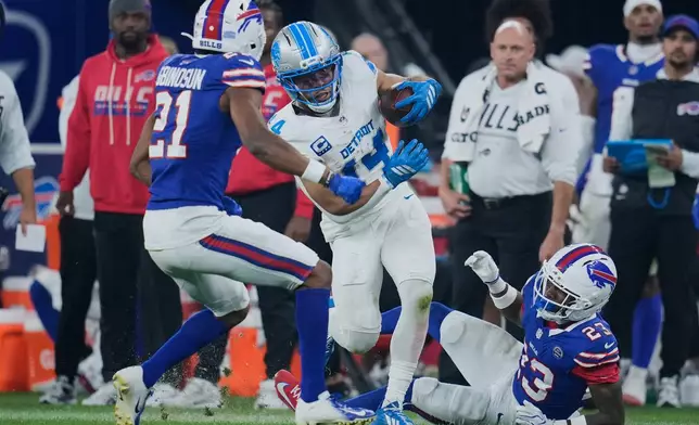 Detroit Lions wide receiver Amon-Ra St. Brown (14) runs after a catch as Buffalo Bills cornerback Davison Igbinosun (21) defends during the second half of an NFL football game in Orchard Park, N.Y., Thursday, Sept. 17, 2026. (AP Photo/Sue Ogrocki)
