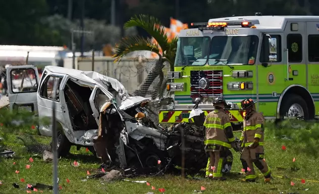 Miami Dade Fire Rescue officials inspect a damaged vehicle two days after an Amazon cargo plane overshot a runway at Miami International Airport, Tuesday, Sept. 8, 2026, in Miami. (AP Photo/Rebecca Blackwell)