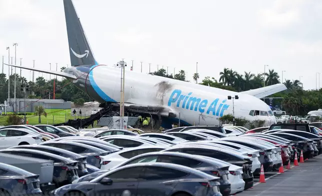 Workers inspect an Amazon cargo plane two days after it overshot a runway at Miami International Airport, Tuesday, Sept. 8, 2026, in Miami. (AP Photo/Rebecca Blackwell)