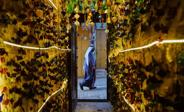 A Palestinian man walks past a glassware shop belonging to the Al-Natsheh family in the West Bank city of Hebron, Monday, Sept. 14, 2026. (AP Photo/Mahmoud Illean)