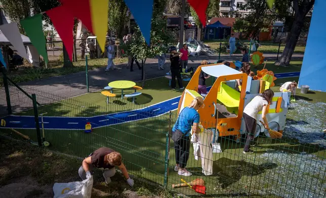Residents clear a playground of debris after a Russian missile strike in Kyiv, Ukraine, Thursday, Sept. 17, 2026. (AP Photo/Dan Bashakov)