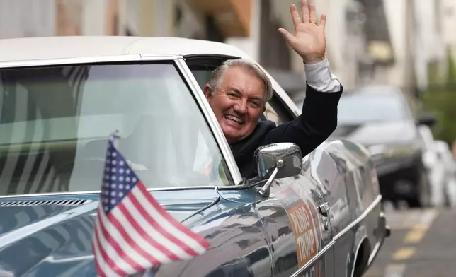 Plinio Vicentin Jr., who is running for federal lawmaker as "Plinio Trump," with the Novo Party representing Minas Gerais state, campaigns from his car ahead of the general election in Juiz de Fora, Minas Gerais state, Brazil, Monday, Sept. 28, 2026. (AP Photo/Silvia Izquierdo)