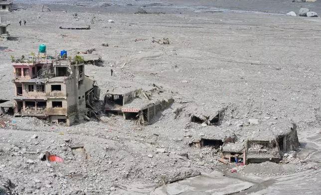 FILE - Houses damaged by recent flash floods stand amid thick layers of sludge, mud and debris in Nepal's Nuwakot district, Sept. 8, 2026. (AP Photo/Dar Yasin, File)