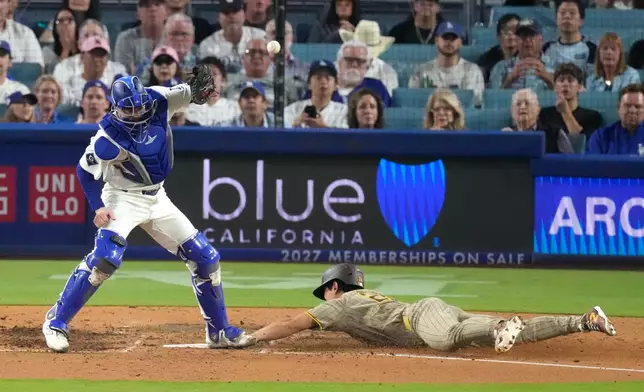 San Diego Padres' Sung-Mun Song, right, scores on a single by Fernando Tatis Jr. as Los Angeles Dodgers catcher Hunter Feduccia misses the ball during the seventh inning of a baseball game Thursday, Sept. 24, 2026, in Los Angeles. (AP Photo/Mark J. Terrill)