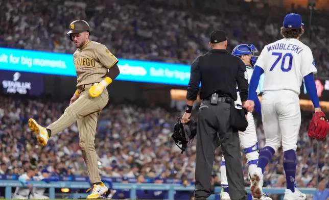San Diego Padres' Jackson Merrill, left, scores on a single by Austin Hays as Los Angeles Dodgers catcher Hunter Feduccia, second from right, and pitcher Justin Wrobleski stand by during the seventh inning of a baseball game Thursday, Sept. 24, 2026, in Los Angeles. (AP Photo/Mark J. Terrill)