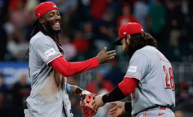 Cincinnati Reds' Elly De La Cruz, left, and Eugenio Suárez (28) celebrate after defeating the Atlanta Braves during the ninth inning of a baseball game, Tuesday, Sept. 22, 2026, in Atlanta. (AP Photo/Erik S. Lesser)