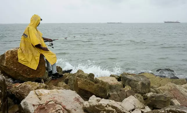 A fisherman who goes by the name "Jellybean" casts his line along the ship channel before landfall of Tropical Storm Edouard in Galveston, Texas, on Tuesday, Sept. 1, 2026. (Brett Coomer/Houston Chronicle via AP)