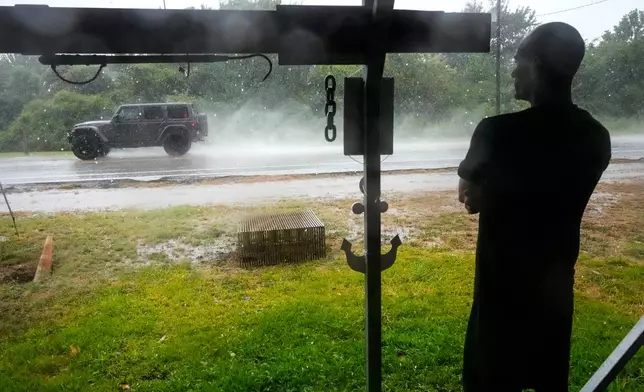 Michael Espinoza stands under the awning of his shop, T&M Bait Shop, watching rain from Tropical Storm Edouard come down in High Island, Texas, on Tuesday, Sept. 1, 2026. (Brett Coomer/Houston Chronicle via AP)