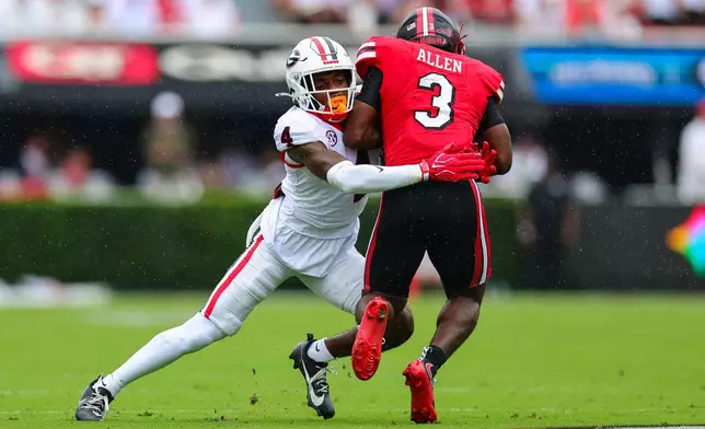 Georgia defensive back KJ Bolden, left, tackles Western Kentucky running back Ajay Allen (3) during the first half of an NCAA college football game, Saturday, Sept. 12, 2026, in Athens, Ga. (AP Photo/Colin Hubbard)