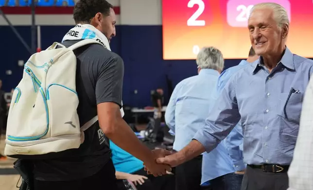 Miami Heat guard Klay Thompson, left, shakes hands with Miami Heat president Pat Riley, right, during NBA basketball training camp, Tuesday, Sept. 29, 2026, in Boca Raton, Fla. (AP Photo/Lynne Sladky)