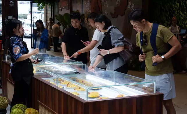 Visitors selecting durian during a tasting session at KLDEX (Kuala Lumpur Durian Experience Centre) in Kuala Lumpur, Malaysia, Friday, June 26, 2026. (AP Photo/Vincent Thian)