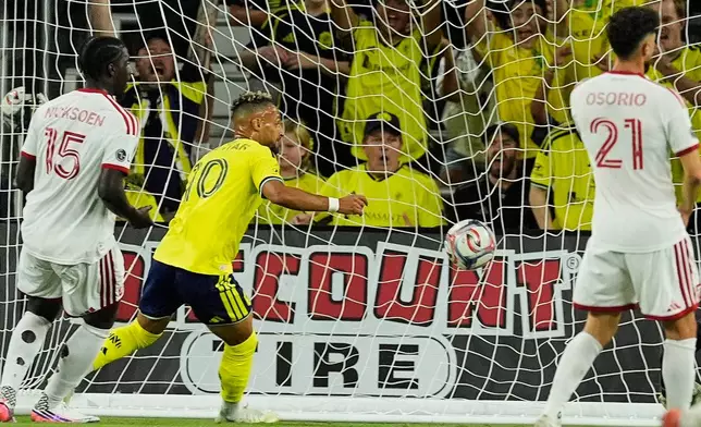 Nashville SC forward Hany Mukhtar (10) scores their opening goal past Toronto FC defender Nicksoen Gomis (15) during the first half of an MLS soccer match Saturday, Sept. 26, 2026, in Nashville, Tenn. (AP Photo/George Walker IV)