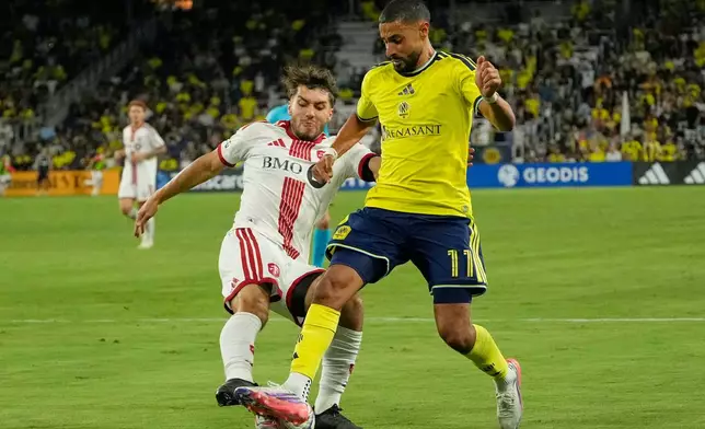 Toronto FC defender Kobe Franklin, left, battles for the ball with Nashville SC forward Elias Saad (11) during the second half of an MLS soccer match Saturday, Sept. 26, 2026, in Nashville, Tenn. (AP Photo/George Walker IV)